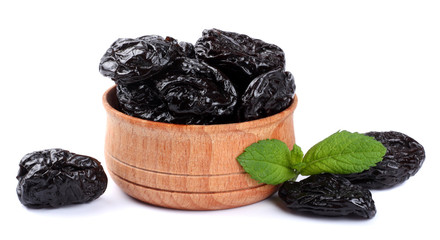 Dried plums - prunes in wooden bowl isolated on white background