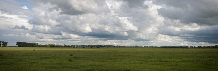 Fototapeta na wymiar panoramic storm clouds over the green field