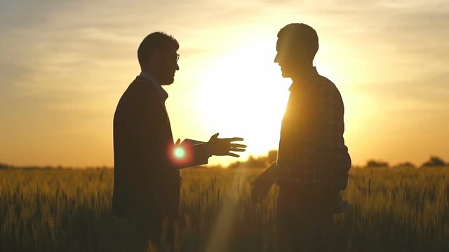Businessman with tablet PC show to farmer terms a deal slow motion