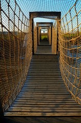 Bridge with rope and net. Blue sky. Vertical photo. Walking adventure.