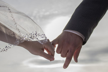 Bride and groom linking pinkies