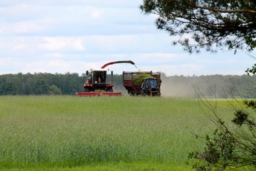 tractor rides around the harvester, the harvester collects the crop