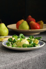 insalata di pere formaggio pepe e valeriana su sfondo scuro