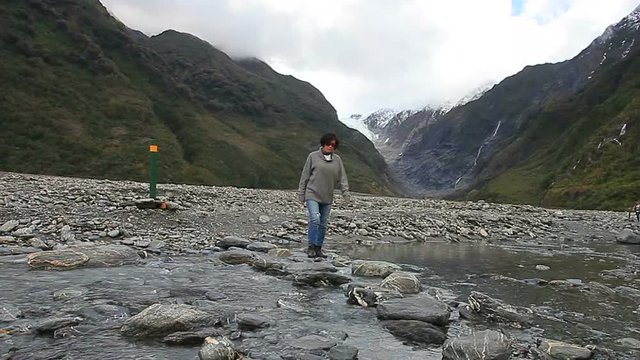 woman tourist walking in franz josef glacier trail most popular traveling destination in south island new zealand