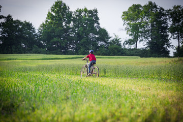 boy ride on bike on rural landscape