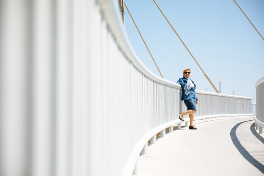 Senior woman leaning on fence