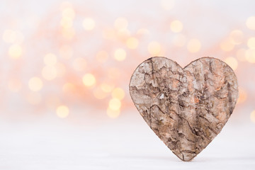 Valentines day greeting card. Wood heart on the light background.