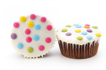 Multiple colorful decorated muffins on a white background.