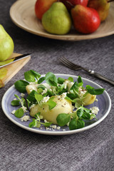 insalata di pere formaggio pepe e valeriana su sfondo scuro