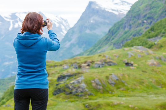 Tourist taking photo in mountains Norway