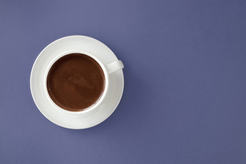 Coffee in white cup on blue background.