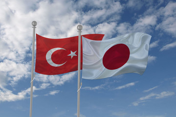 Turkey and Japan flag waving in the sky