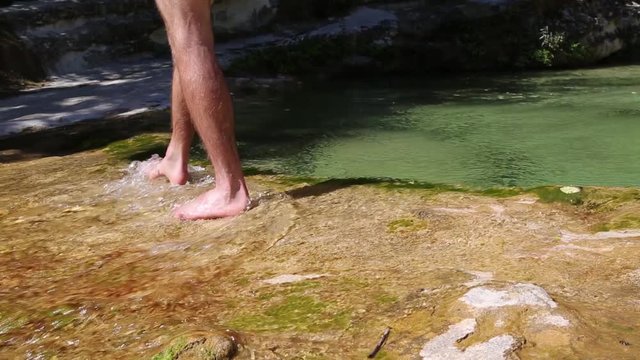 Uomo attraversa un fiume a piedi nudi