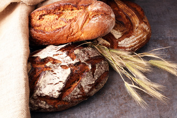Different kinds of bread and bread rolls on board from above. Kitchen or bakery poster design.