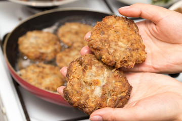 Fried chicken in a frying pan in hand