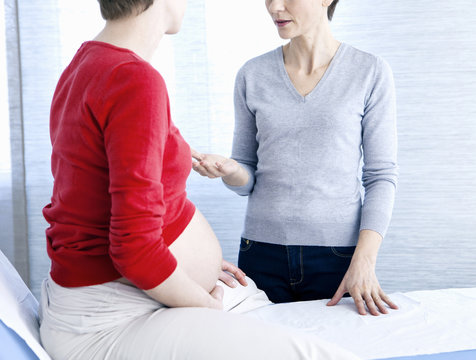 Pregnant woman and doctor talking
