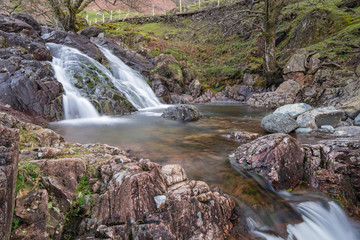 One of the waterfalls on Stickle Ghyll in the English Lake District cascading into a clear pool during spring time. A popular tourist path it is a short car journey from Ambleside.