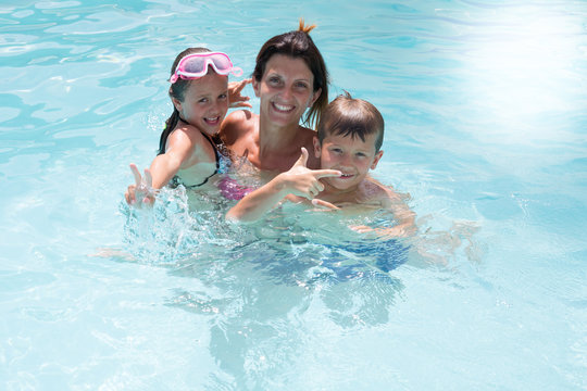 beautiful family with child in pool summer