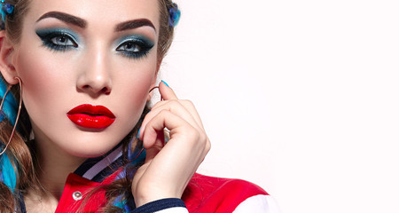 Beautiful young girl with long bright braids. Blue hair, weaving, Bright makeup, red jacket. Cosmetics. Photoshoot on a white background.