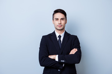 Successful young handsome brunete hispanic man lawyer in a suit on pure background with crossed hands. Severe and harsh, rich and confident, attractive and smart