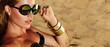 Beautiful young tanned healthy girl in bikini lies on the beach. Bright sun, summer, heat, rest. Accessories - sunglasses, gold bracelets. Beach, sand, rest, travel. Beautiful tanned skin.