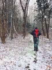 A man with a backpack walks through the forest