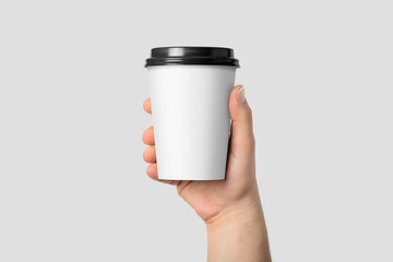 Mockup of male hand holding a Coffee paper cup isolated on light grey background.  - Powered by Adobe