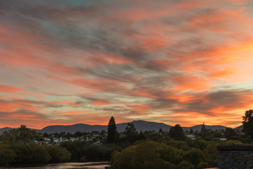 Queenstown, New Zealand - March 16, 2017: Sunrise over Lake Wakitupu and town paints parts of sky...
