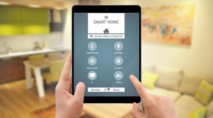Man control smart home system on his tablet, living room in background