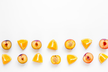 tropical fruits design with orange and peach on white table background top view mock up