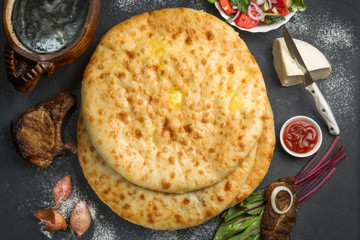 Delicious Ossetian pies on the table surrounded by components