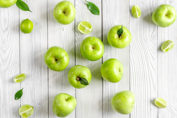 Plakat natural food design with green apples white desk background top view