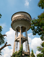 Old water tank tower with clouds and blue sky