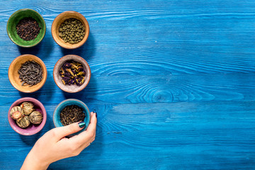 Tea-party with different herbal tea on blue desk background flat lay mock up
