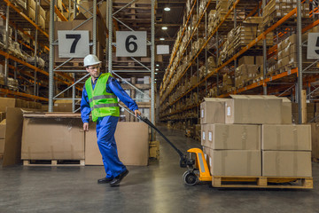 Warehouse worker dragging a cart with merchandise