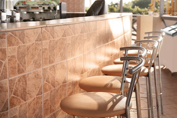 Bar stools lined up at outdoor bar
