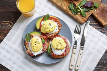 Tasty eggs Benedict on plate, top view