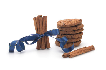 Oatmeal cookies with chocolate, cinnamon sticks on white background