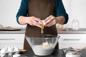 Woman making dough for butter cookies in kitchen