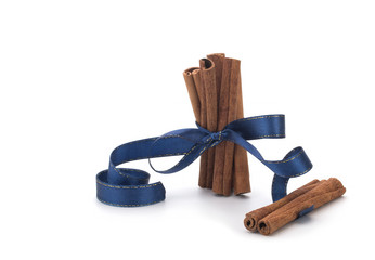 Festive wrapped cinnamon sticks isolated on white background