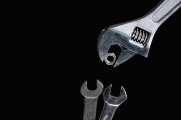 One adjustable wrench, two feeds a spanner nut on a black background
