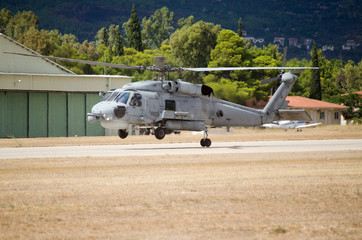 Fototapeta na wymiar Black hawk helicopter rescue team landing on airfield, one back wheel touches the ground