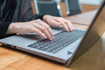Businesswoman typing on laptop at workplace and working at office hand on keyboard close up