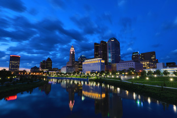 Fototapeta na wymiar The skyline of the city of Columbus along the Scioto river at dusk with the Scioto Greenway in the foreground along the river.