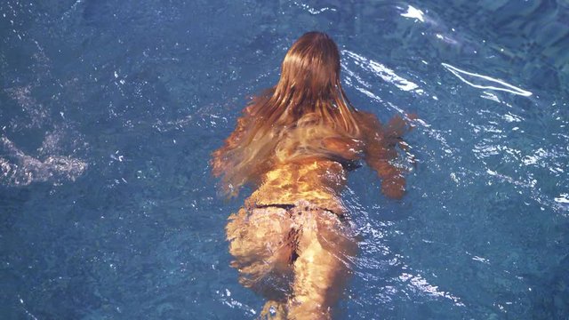 Sexy woman in swimming pool. Woman swimmer in swimming pool. Sexy woman swimming in slow motion. Sexy girl with blonde hair swimming in blue water. Sexy swimmer