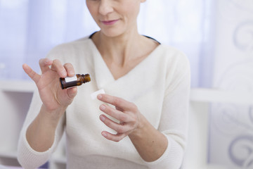 Woman pouring essential oil on a sugar