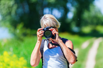 mature woman taking photos with a camera