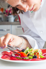 chef preparing dish with bersaola and mixed salad