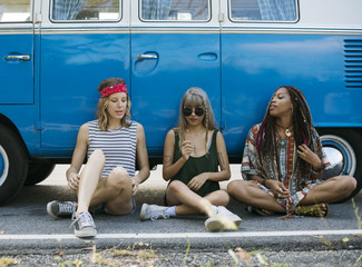 Group of Diverse Friends on Road Trip Sitting by the Car Together