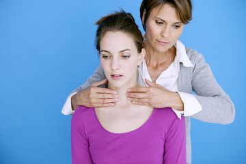 Doctor examining the thyroid of a patient